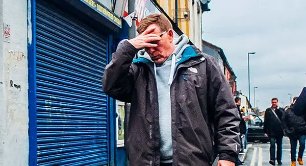 Man with headache walking on street